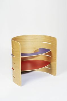 a wooden shelf with three different colored plates on it's sides and one in the middle