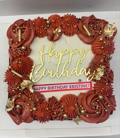 a birthday cake with red flowers and gold decorations