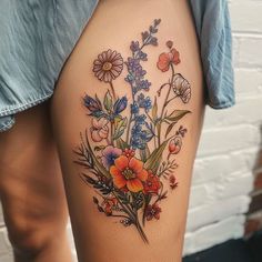 a woman's thigh with flowers and leaves on her thighs, showing the tattoo design