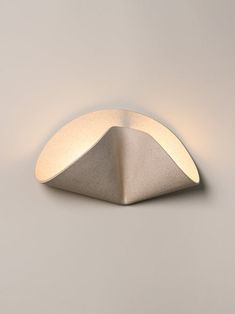 a light that is on the side of a wall in front of a gray background