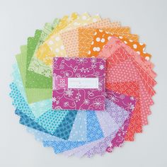 a bunch of different colored papers on top of each other in various colors and patterns