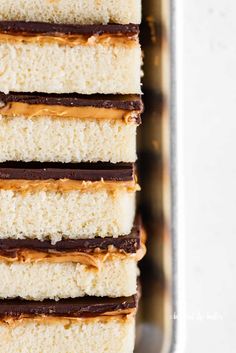 four pieces of cake in a pan with peanut butter frosting and chocolate on top