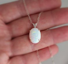 "Beautiful Large white lab-created opal pendant necklace. These gorgeous opals are very similar to natural mined opals. Lab-created opals contain 70-90% silica (from which natural opal is formed) and 10-30% resin. The resin makes the opal harder, stronger, unlike natural opals, which are known to be soft and fragile. Each opal displays a rainbow of color that sparkles with every catch of light. I've handset two different size opals in a solid sterling silver prong settings 16x12mm (5/8\" x 1/2\" White Opal Jewelry Gift, White Opal Round Pendant Necklace, White Opal Pendant Jewelry, White Opal Gemstone Necklace, White Opal Birthstone Jewelry, White Oval Opal Necklace, White Opal Necklace For Gift, Elegant White Pink Opal Jewelry, White Pink Opal Gemstone Jewelry