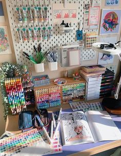 a desk with many different colored pencils and pens on it, along with other office supplies