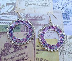 two pairs of beaded hoop earrings sitting next to each other on top of a piece of paper