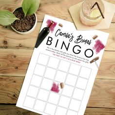 a printable game is sitting on top of a wooden table next to a potted plant