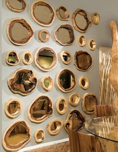 a wall that has some mirrors on it and is made out of wood slices with holes in the middle