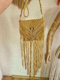 "Welcome to Creative Macrame Art 😊  Macrame bag in boho style with gold tone metal tubes and long fringes. This amazing macrame bag it is made from polyester macrame thread soft touch accessorized with metal tubes.  To realized this macrame bag with fringes I used Art of macrame. Dimensions: Height: 8\" Length: 7\" Strap Length: 48\" The strap of the bag it is realized using aluminium chain braided with polyester macrame yarn  😉 Strap of the fringe macrame bag it's removable." Handmade Gold Shoulder Bag For Festival, Handmade Gold Bags For Festivals, Bohemian Straw Bag With Fringe, Bohemian Gold Bags For Everyday Use, Handmade Gold Shoulder Bag For Beach, Handmade Gold Shoulder Bag For Summer, Bohemian Weaving Bags For Gift, Bohemian Weaving Bags As Gift, Adjustable Bags For Summer Festivals