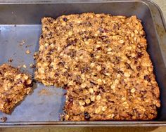 an oatmeal and raisin granola bar in a baking pan with one slice missing