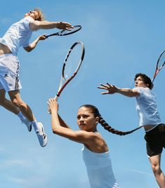 three tennis players are jumping up in the air with their racquets raised