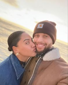 a man and woman kissing on the beach