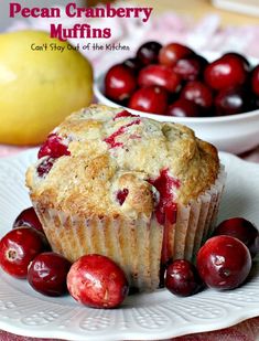 a muffin on a plate with cherries next to it