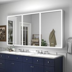 a bathroom with double sinks and large mirrors