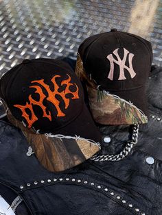 These hats are black and camo with an asymmetrical barbed wire trim. Default threads used are 100% rayon and offered in grey, blue, rose gold, white, rust orange, and champagne. HOWEVER, I have tons of thread options including woold thread in a multitude of colors. Please message for additional color options and I can send you photos of the threads I have available. Please also message me for additional lettering or symbols. Currently the metal font is default, however again, you can message me Streetwear Fall Baseball Cap With Curved Brim, Fall Streetwear Baseball Cap With Curved Brim, Curved Brim Hats For Fall Streetwear, Fall Streetwear Baseball Cap, Military Style Camouflage Trucker Hat, Camouflage Military Trucker Hat For Streetwear, Custom Embroidered Hats, Metal Font, Military Camouflage Snapback Hat With Curved Brim