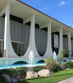 a large building with columns on the front and water fountain at the entrance to it