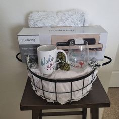 a basket with two coffee mugs and some other items on it, sitting on top of a table