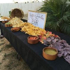 a table topped with lots of different types of chips and dips on top of it