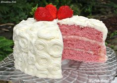 a strawberry cake with white frosting and two strawberries on top