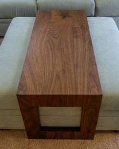 a large wooden table sitting on top of a carpeted floor next to a couch