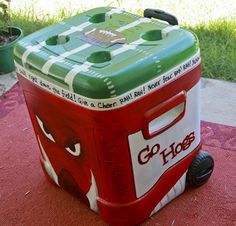 a red and green cooler sitting on top of a rug