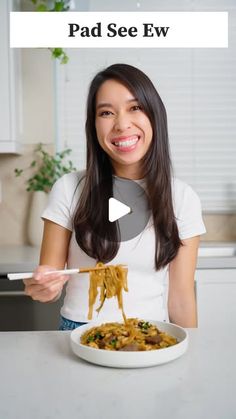 a woman holding a plate of food with the caption pad see ew