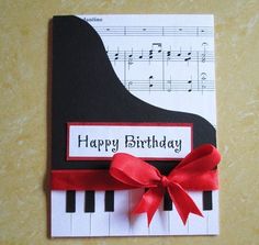 a happy birthday card with a piano and red ribbon on it's side,