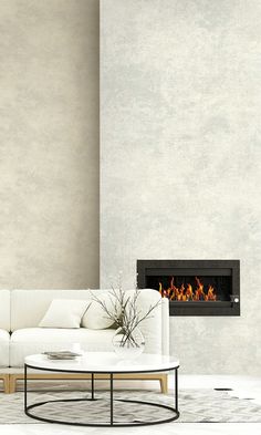 a living room with a white couch and fire place in the corner, next to a wall mounted fireplace