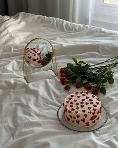 a white cake sitting on top of a bed next to a mirror with hearts drawn on it