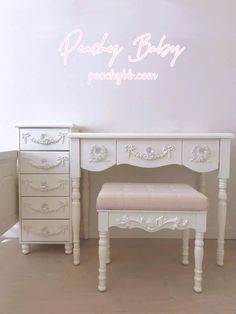 a white vanity with drawers and a bench in front of a wall that says ready baby