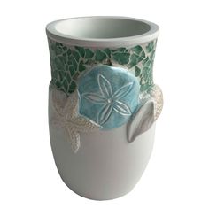 a ceramic vase with sand dollar and starfish on the bottom, sitting in front of a white background