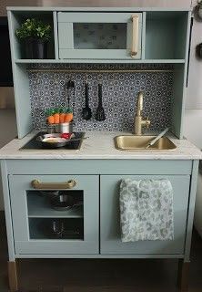 a toy kitchen with sink, stove and microwave