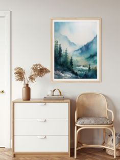 a painting hanging on the wall next to a chair and table with a potted plant