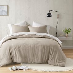 a bed in a bedroom with beige sheets and pillows