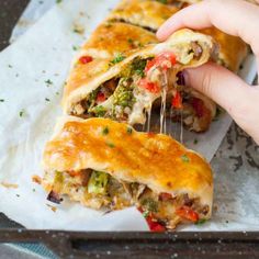 someone is taking a piece of pizza out of the baking pan with their hand on it