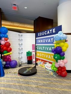 there are many balloons on the floor in front of a sign that says graduate innovat