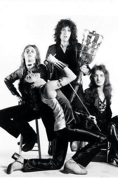 the band queen posing for a photo with their trophies