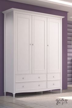 a white armoire with drawers in a purple and white room next to a bed