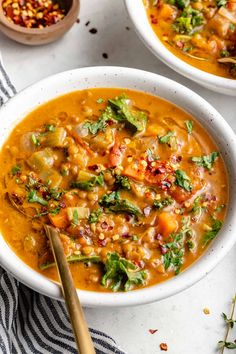 two white bowls filled with soup on top of a table