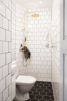 a white toilet sitting next to a shower in a bathroom under a faucet