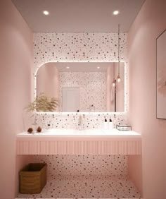 a bathroom with pink walls and polka dot wallpaper on the walls, along with a sink