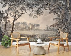 two chairs and a table in front of a wall mural