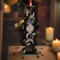 a candle holder made out of snakes with a pentagramus symbol on the top