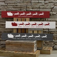 three wooden signs with santa's sleigh and reindeers on them in front of a stone wall