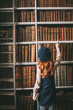 a woman standing in front of a bookshelf with lots of books on it