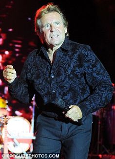 a man standing in front of a stage with his hands on his hips and mouth open