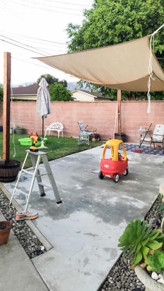 a child's toy car is parked in the backyard with an umbrella over it