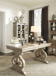 a living room filled with furniture and a large table in front of a book shelf