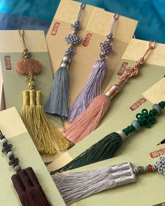 some tassels are laying on top of each other in different colors and designs