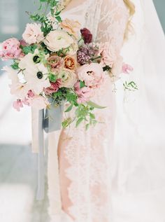 a bride holding a bouquet of flowers in her hand