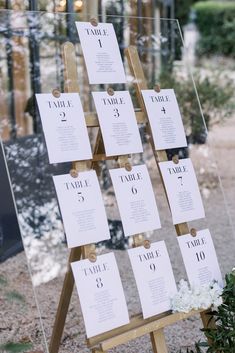 a wooden easel with seating cards on it